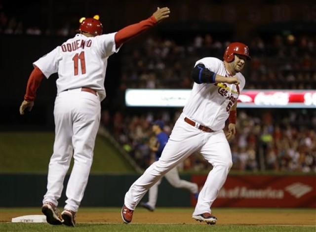St. Louis Cardinals Third-base coach Jose Oquendo waves home Matt Adams